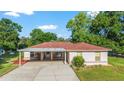 Charming single-story home featuring a well-manicured lawn, neutral exterior, and convenient carport at 10140 Sw 81St Terrace Rd, Ocala, FL 34481