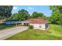 Inviting single-story home featuring a carport, well-kept lawn, and landscaping with a charming and appealing facade at 10140 Sw 81St Terrace Rd, Ocala, FL 34481