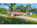 Well-maintained single-story home with long driveway, carport, lush lawn, and mature trees, offering great curb appeal at 10140 Sw 81St Terrace Rd, Ocala, FL 34481