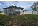The back of a gray house with a satellite, awnings, and an air conditioning unit on a lawn at 10330 Sw 99Th Ave, Ocala, FL 34481