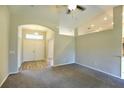 Spacious living room featuring a neutral color scheme, high ceiling, and a ceiling fan at 11609 Sw 59Th Ter, Ocala, FL 34476