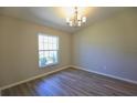 Bright room with wood-look floors, chandelier, and a window providing natural light at 11609 Sw 59Th Ter, Ocala, FL 34476
