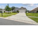 Beautiful home with long driveway, well-kept lawn, and charming exterior is bathed in natural light at 1317 Ravida Woods Dr, Apopka, FL 32703