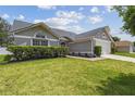 Charming home with lush green lawn and manicured hedges; a welcoming facade with ample sunlight at 1317 Ravida Woods Dr, Apopka, FL 32703