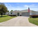 Delightful one-story home with a screened two-car garage, American flag, and mature landscaping at 13618 Sw 111Th Cir, Dunnellon, FL 34432