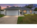 Beautiful single-story home with an attached garage, manicured lawn and dark trim around windows at 14118 Sw 32Nd Terrace Rd, Ocala, FL 34473