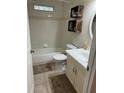 Bright bathroom with tub, toilet and sink with vanity and updated fixtures and shelving at 14121 Nw Highway 225, Reddick, FL 32686