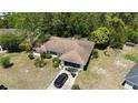 Aerial view of single-story home with a brown roof, screened lanai, and black SUV in driveway at 15920 Sw 49Th Court Rd, Ocala, FL 34473
