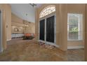 Home foyer featuring neutral walls, tile floors, a large entry door, and a glimpse into an adjacent sitting area at 2272 Se Laurel Run Dr, Ocala, FL 34471