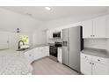 The bright kitchen has stainless steel appliances and sleek granite countertops, and white cabinets at 23131 Sw Rainelle Rd, Dunnellon, FL 34431