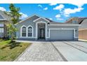 Inviting home featuring a two-car garage, elegant entrance, and manicured landscaping at 2525 Sand Arbor Cir, Orlando, FL 32824