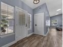 Bright entryway featuring wood-look floors, a decorative front door, and large windows offering ample natural light at 260 Country Circle W Dr, Port Orange, FL 32128