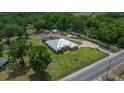 Large property with a pool, accessory structures, and a mix of open land and mature trees at 3934 Se 110Th St, Belleview, FL 34420
