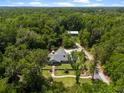 Expansive aerial view of a home nestled amidst lush greenery, showcasing its stone accents, gray roof, and beautiful surroundings at 400 Se 90Th St, Ocala, FL 34480
