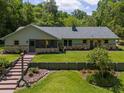 Charming single-story home with stone accents, gray roof, walkway and beautifully manicured lawn, surrounded by mature trees at 400 Se 90Th St, Ocala, FL 34480