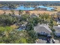 Expansive aerial view of a lakeside community with lush trees and a community pool on the grounds at 588 Fairways Ln # E204, Ocala, FL 34472