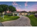 Well-maintained single-story home featuring an attached garage, landscaped front yard, and curved brick driveway at 6858 Sw 111Th Loop, Ocala, FL 34476
