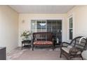 Outdoor patio with brick flooring and features a wicker bench with cushions, perfect for outdoor relaxation at 6858 Sw 111Th Loop, Ocala, FL 34476