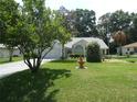 Landscaped front yard with a fountain and lush green lawn at 8765 Sw 190Th Cir, Dunnellon, FL 34432