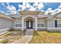 Inviting home entrance with classic white columns, stylish lighting fixtures, and elegant glass front door at 9859 Sw 45Th Ave, Ocala, FL 34476