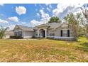 Beautiful home with blue shutters, featuring an open lawn area, and a charming front entryway at 9859 Sw 45Th Ave, Ocala, FL 34476