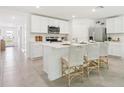 Bright kitchen with white cabinets, stainless steel appliances, and a breakfast bar with stylish seating at 10490 Se 162Nd Place Rd, Summerfield, FL 34491