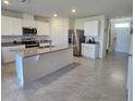 Modern kitchen with stainless steel appliances, a central island, and tile flooring at 1114 Brimstone Cir, Winter Haven, FL 33884