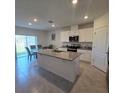 Bright eat-in kitchen with stainless appliances, a large island, and sliding glass doors to the back at 1114 Brimstone Cir, Winter Haven, FL 33884