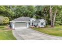 Charming single-story home featuring a well-manicured lawn and a welcoming two-car garage with paved driveway at 11569 Sw 75Th Cir, Ocala, FL 34476