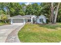 Charming single-story home featuring a well-manicured lawn and a welcoming two-car garage with paved driveway at 11569 Sw 75Th Cir, Ocala, FL 34476