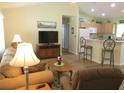 Inviting living room featuring a cozy sofa, TV, and an open layout to the kitchen at 11628 Sw 140Th Loop, Dunnellon, FL 34432