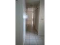Bright hallway with tiled floors and white doors, leading to various rooms in the home at 12 Brook Pl, Ocala, FL 34472
