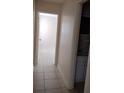 Hallway with access to bedroom and bathroom, featuring neutral paint and tiled floors at 12 Brook Pl, Ocala, FL 34472