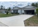 Inviting single-story home featuring a spacious driveway leading to an attached garage, surrounded by well-manicured landscaping at 12 Hickory Course Way, Ocala, FL 34472