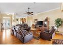 Spacious living room with hardwood floors, crown molding, and a ceiling fan at 12255 Se 177Th Loop, Summerfield, FL 34491