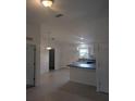 Open-concept kitchen with modern lighting, white cabinets, and a breakfast bar at 15 Juniper Trail Crse, Ocala, FL 34480