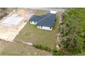 Aerial view of a newly built home with dark roof, lush backyard, and the foundation of another home nearby at 16890 Sw 39Th Cir, Ocala, FL 34473