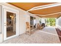 Inviting covered patio with stylish pavers, an awning, and comfortable seating area perfect for outdoor relaxation at 1736 Watts Mill Way, The Villages, FL 32162