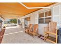 Relaxing covered patio with neutral pavers, protective awning, and cozy seating arrangement for peaceful outdoor living at 1736 Watts Mill Way, The Villages, FL 32162