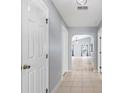 Hallway with tile flooring leads into a bright living area, with multiple entry ways at 17902 Se 115Th Cir, Summerfield, FL 34491