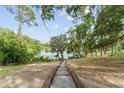 Tranquil backyard with wooden steps leading down to the water, providing direct lake access at 19938 Burkitt Rd, Dunnellon, FL 34432