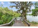 Private wooden dock overlooking serene lake waters, surrounded by lush foliage and hanging moss at 19938 Burkitt Rd, Dunnellon, FL 34432