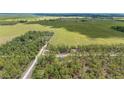 Expansive aerial view of a countryside landscape featuring lush green fields and dense forests, exuding serenity at 23964 Nw Falcon Ave, Dunnellon, FL 34431