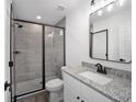 Bathroom featuring granite countertops, gray tiled shower with a glass door and modern fixtures at 23964 Nw Falcon Ave, Dunnellon, FL 34431