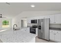Bright kitchen with granite counters, stainless appliances, and white cabinetry at 23964 Nw Falcon Ave, Dunnellon, FL 34431