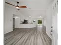 Open-concept living space with modern gray flooring and a view of the kitchen and front entryway at 23964 Nw Falcon Ave, Dunnellon, FL 34431