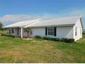 Inviting single-story home with lush landscaping, a metal roof, and a manicured lawn at 258 Nw 122Nd Ave, Oxford, FL 34484