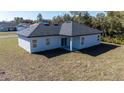 View of the rear exterior featuring a covered porch, sliding glass door, and lawn at 2627 Sw 154Th Place Rd, Ocala, FL 34473