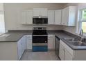 Well-equipped kitchen features stainless steel appliances, granite counters, and bright white cabinets at 2803 Sw 147Th Ct, Ocala, FL 34481