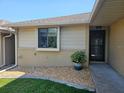 A quaint front entry featuring a decorative stone garden and a screened front door at 5024 Se 107Th Pl, Belleview, FL 34420